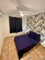 a bedroom with a purple bed and a ceiling fan at Le Toucan Tropical, F2 bis emplacement central in Fort-de-France