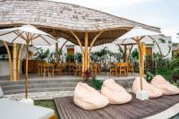 a group of chairs and umbrellas on a deck at Shanti Boutique Retreat in Tanah Lot