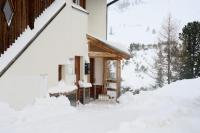 a house covered in snow with snow on the porch at Alpina Holiday Living Apartments in Obertauern