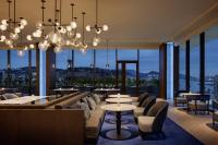 um restaurante com mesas e cadeiras e grandes janelas em Nagasaki Marriott Hotel em Nagasaki