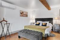 a bedroom with a large bed with a bench in it at Au Nid de la Madeleine in Gaillac