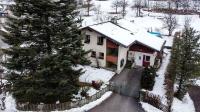 a house with a christmas tree in the snow at Appartement Mountainrelax Gastein in Dorfgastein