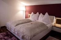 a bedroom with a large white bed with a red wall at Appartement Mountainrelax Gastein in Dorfgastein