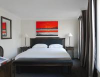 a bedroom with a bed and a painting on the wall at Hotel Royal Saint Honore Paris Louvre in Paris