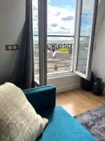 a room with a blue couch and a large window at Rooms with fabulous view on Paris roofs in Paris