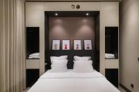 a bedroom with a large bed with white pillows at Maison Nô - Hôtel et Rooftop in Lyon