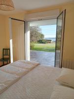 a bedroom with a bed and a sliding glass door at Parenthese relaxante les pieds dans l eau in Le Tour-du-Parc