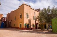 a large brick building with graffiti on the side of it at Kasbah Omari in Tinerhir