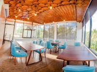 un comedor con mesas de madera y sillas azules en Ceylanro Transit Villa, en Negombo
