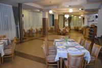 Хотел Дикас في سموليان: غرفة طعام مع طاولات بيضاء وكراسي وطاولة