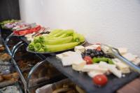 una mesa cubierta con platos de queso y verduras en Hotel NOBEL Ulcinj, en Ulcinj