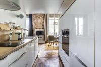 a kitchen with white cabinets and a dining room at Le petit Opéra in Lyon
