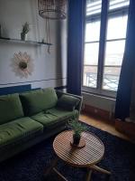 a living room with a green couch and a table at Le petit Opéra in Lyon