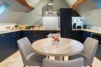 a kitchen with blue cabinets and a wooden table and chairs at Escale de Giulia in Beaune