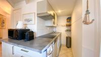 a kitchen with white cabinets and a counter top at Appartement dans résidence avec piscine proche plage et commerces in La Couarde-sur-Mer