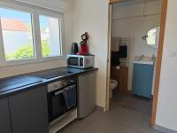 a small kitchen with a microwave on a counter at 2Appartement dans un pavillon ac vue sur le jardin in Argenteuil