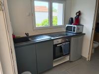 a kitchen with a sink and a microwave at 2Appartement dans un pavillon ac vue sur le jardin in Argenteuil