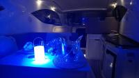 un camping-car avec une lumière bleue sur une table dans l'établissement Cap Saint Martin Marina, au Cap d'Agde