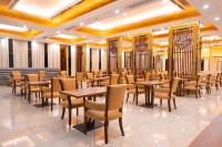 Un restaurante con mesas y sillas en un edificio. en ST Vegas Hotel, en Ban Nong-Heo