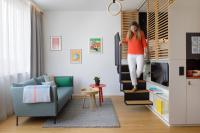 a woman is jumping off of a tv in a living room at Zoku Vienna in Vienna