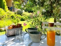 a table with a bottle of orange juice and a basket of bread at Mas des Marguerites in Maussane-les-Alpilles