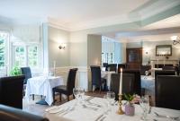 un comedor con mesas, sillas y mesa de comedor en Findon Manor Hotel, en Worthing