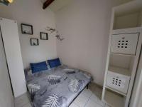a small bedroom with a bed with blue pillows at Appartement Marseillan-Plage, 2 pièces, 6 personnes - FR-1-326-798 in Marseillan