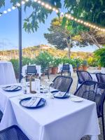 a table with white table cloths and chairs at a restaurant at Hôtel Helios &amp; SPA - Ile des Embiez in Six-Fours-les-Plages