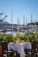 a table with food and a view of a marina at Hôtel Helios &amp; SPA - Ile des Embiez in Six-Fours-les-Plages