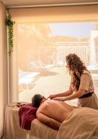 a woman is giving a man a massage at Hôtel Helios &amp; SPA - Ile des Embiez in Six-Fours-les-Plages