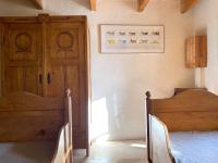 a bedroom with two beds and a wooden door at Gîte de charme avec grand jardin &amp; piscine in Touffailles