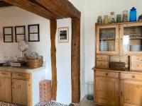 a kitchen with wooden cabinets and a clock on the wall at Gîte de charme avec grand jardin &amp; piscine in Touffailles