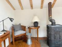 a room with a stove and a chair and a lamp at Gîte de charme avec grand jardin &amp; piscine in Touffailles
