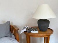 a lamp on a table next to a bed at Gîte de charme avec grand jardin &amp; piscine in Touffailles