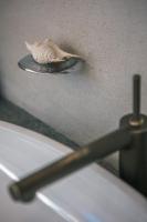 a shell sitting on a wall next to a sink at 57villa in Hengchun South Gate