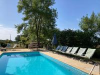 a swimming pool with lounge chairs and an umbrella at Gîte de charme avec grand jardin &amp; piscine in Touffailles