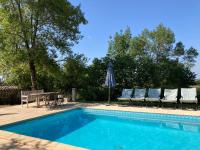 a pool with chairs and a table and an umbrella at Gîte de charme avec grand jardin &amp; piscine in Touffailles
