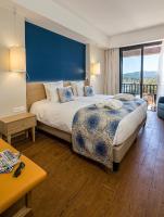 a bedroom with a large bed with a blue wall at Hôtel Helios &amp; SPA - Ile des Embiez in Six-Fours-les-Plages