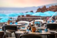 una mesa con copas de vino y una maceta en un patio en Tiara Miramar Beach Resort, en Théoule-sur-Mer