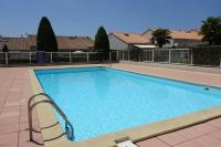 a large swimming pool with two chairs next to it at Vaux sur Mer - côté PONTAILLAC - VILLA MITOYENNE - PISCINE COLLECTIVE in Vaux-sur-Mer