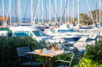 a table and chairs with boats in a marina at Hôtel Helios &amp; SPA - Ile des Embiez in Six-Fours-les-Plages