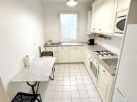 a white kitchen with white cabinets and a table at Disney et Paris pour 4 personnes RER A in Champs-sur-Marne