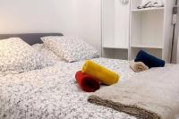 ein Bett mit Kissen und Decken darauf in der Unterkunft Appartement 4 personnes Paris in Pontault-Combault