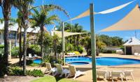 una piscina con sillas y sombrillas blancas en Mercure Bunbury Sanctuary Golf Resort, en Bunbury