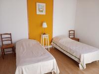 two beds in a room with two chairs and a lamp at Gîte Arthon, 5 pièces, 8 personnes - FR-1-591-372 in Arthon