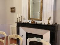 a fireplace with a mirror and two chairs in a room at Gîte Bazouges-sur-le-Loir, 6 pièces, 10 personnes - FR-1-410-377 in Bazouges-sur-le-Loir