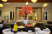 una mesa con platos de comida y un árbol en ella en Front One Hotel Sragen, en Sragen