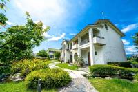 a white house with a balcony and a yard at Yun Tien Feng Chuan B&amp;B in Dongshan