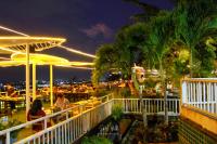 Un restaurante con palmeras y mesas por la noche. en Sky View Luxury Pool Villa - SHA, en Suratthani