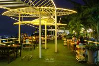 Un grupo de personas sentadas en mesas en un tejado. en Sky View Luxury Pool Villa - SHA, en Suratthani